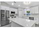 Bright kitchen with stainless steel appliances, a large island, and white cabinets at 4314 Se 131St Ln, Belleview, FL 34420