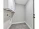 Clean, bright laundry room with white cabinets, gray walls, and gray tile flooring at 4314 Se 131St Ln, Belleview, FL 34420