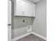 Laundry area featuring white cabinets and gray tile flooring at 4314 Se 131St Ln, Belleview, FL 34420