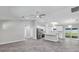 Open-concept living space featuring gray tiled floors, white cabinets, modern light fixtures and stainless steel appliances at 4314 Se 131St Ln, Belleview, FL 34420