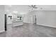 Open-concept living space featuring gray tiled floors, white cabinets, modern light fixtures and stainless steel appliances at 4314 Se 131St Ln, Belleview, FL 34420