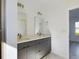 Bright bathroom featuring double sink vanity with large mirrors and modern fixtures at 4415 Sw 169Th Lane Rd, Ocala, FL 34473