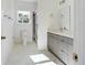 Bright bathroom featuring white marble floors, grey vanity, glass shower, and window offering natural light at 4415 Sw 169Th Lane Rd, Ocala, FL 34473