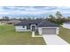 A single-story home with neat lawn, showcasing the front facade, two-car garage, and neutral color scheme at 4415 Sw 169Th Lane Rd, Ocala, FL 34473