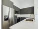 Modern kitchen featuring dark cabinets, quartz countertops, stainless steel appliances, and a sleek refrigerator at 4415 Sw 169Th Lane Rd, Ocala, FL 34473