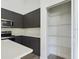 Well-organized pantry and a modern kitchen with stainless steel appliances and dark cabinets at 4415 Sw 169Th Lane Rd, Ocala, FL 34473