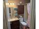Cozy bathroom with dark wood cabinetry, shower and tub, complemented by stylish decor and accessories at 5024 Se 107Th Pl, Belleview, FL 34420