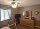 This bedroom offers a ceiling fan, a wall-mounted TV, a dresser with mirror, and natural light from the window at 5024 Se 107Th Pl, Belleview, FL 34420