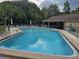 Community swimming pool with lounge chairs and tables, ideal for recreation and relaxation at 5024 Se 107Th Pl, Belleview, FL 34420