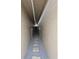Long walkway with stone path and gravel on both sides, creating a narrow passage between the building's walls at 5024 Se 107Th Pl, Belleview, FL 34420