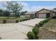 Charming single-story home with a two-car garage and a long driveway lined with manicured shrubs at 516 Marion Oaks Dr, Ocala, FL 34473