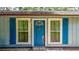 Charming front door features a unique design, flanked by windows with blue shutters and a welcoming exterior at 5737 Nw 65Th Pl, Ocala, FL 34482