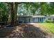 Single-story home featuring blue shutters, a brick walkway, and a large tree providing shade to the front yard at 5737 Nw 65Th Pl, Ocala, FL 34482