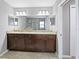 Bathroom with tile floors, glass shower, granite counters, dual sinks and large mirror at 60 Hemlock Trl, Ocala, FL 34472