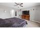 Primary bedroom with neutral walls, gray carpet, large bed and TV on wooden dresser at 60 Hemlock Trl, Ocala, FL 34472