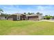 A well-maintained single-story home with green lawn and a long driveway to the two car garage at 60 Hemlock Trl, Ocala, FL 34472
