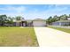 Charming single-story home featuring a manicured lawn, a long driveway, and a two-car garage at 60 Hemlock Trl, Ocala, FL 34472