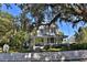 Charming yellow two-story home with a welcoming front porch and white picket fence at 743 E Fort King St, Ocala, FL 34471