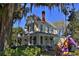 Charming yellow two-story home with a welcoming front porch and colorful horse statue at 743 E Fort King St, Ocala, FL 34471