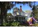 Charming yellow two-story home with a welcoming front porch and colorful horse statue at 743 E Fort King St, Ocala, FL 34471