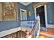 Stairway with wooden banister, blue walls, and vintage details leading to the upper level at 743 E Fort King St, Ocala, FL 34471