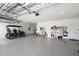 Spacious garage featuring epoxy floors, overhead storage racks and a golf cart at 8457 Sw 97Th Cir, Ocala, FL 34481