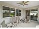 Covered patio featuring comfortable seating and a ceiling fan, with sliding glass doors offering seamless indoor-outdoor living at 8457 Sw 97Th Cir, Ocala, FL 34481