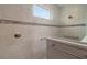 Modern tiled shower featuring sleek fixtures and a glass enclosure, bathed in natural light from a nearby window at 8457 Sw 97Th Cir, Ocala, FL 34481