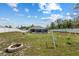 Large backyard with a fire pit, swing set, screened-in pool, and white fencing at 9940 Sw 45Th Ave, Ocala, FL 34476