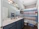 Bathroom with blue vanity and white marble countertop, with a shower and toilet at 9940 Sw 45Th Ave, Ocala, FL 34476