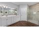 Elegant bathroom featuring a double vanity, a large walk-in shower, wood look tile floor and ample natural light at 9940 Sw 45Th Ave, Ocala, FL 34476