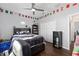Bedroom featuring hardwood floors, closet, ceiling fan, and flag decorations at 9940 Sw 45Th Ave, Ocala, FL 34476