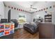 Bright bedroom with a flag themed decor, wood floors, a ceiling fan, and a window for plenty of natural light at 9940 Sw 45Th Ave, Ocala, FL 34476