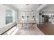 Bright dining area with modern chandelier, wainscoting, wood-look tile floors, and abundant natural light at 9940 Sw 45Th Ave, Ocala, FL 34476