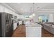 Open kitchen with stainless steel appliances, granite countertops, island seating, and wood flooring at 9940 Sw 45Th Ave, Ocala, FL 34476