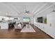 Open-concept living room with tray ceilings, wood-look tile floors, and access to the kitchen at 9940 Sw 45Th Ave, Ocala, FL 34476