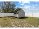 Backyard shot of a neutral-colored storage shed with double doors and a charming design at 9940 Sw 45Th Ave, Ocala, FL 34476