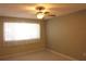 Neutral bedroom featuring a ceiling fan, bright natural light, and neutral color laminate flooring at 10843 Sw 91St Ter, Ocala, FL 34481