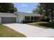 Charming single-story home featuring a white exterior, well-maintained lawn, and an attached two-car garage at 10843 Sw 91St Ter, Ocala, FL 34481