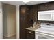 Modern kitchen featuring brown cabinetry, white appliances, and granite countertops, perfect for cooking enthusiasts at 10843 Sw 91St Ter, Ocala, FL 34481