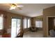 Sun-filled living room with a ceiling fan, dining table, and access to the backyard, creating an inviting space at 10843 Sw 91St Ter, Ocala, FL 34481