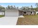 Charming single-story home showcasing a well-manicured lawn, a two car garage and modern architectural details at 13349 Sw 113Th Pl, Dunnellon, FL 34432