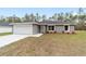 Charming single-story home showcasing a well-manicured lawn, a two car garage and modern architectural details at 13349 Sw 113Th Pl, Dunnellon, FL 34432