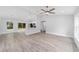The open-concept living room featuring vaulted ceilings, vinyl flooring, a ceiling fan, and views to the backyard at 13349 Sw 113Th Pl, Dunnellon, FL 34432