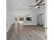 The open-concept living room featuring vaulted ceilings, vinyl flooring, a ceiling fan, and views to the backyard at 13349 Sw 113Th Pl, Dunnellon, FL 34432