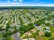 Wonderful aerial view of the home in a vibrant 55+ community with mature trees and lush landscaping at 13885 Del Webb Blvd, Summerfield, FL 34491