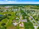 Gorgeous aerial view of home in 55+ community with golf course, landscaping, and nearby shopping at 13885 Del Webb Blvd, Summerfield, FL 34491