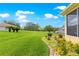 Beautifully landscaped backyard featuring lush greenery, decorative plants, and a serene view of the property at 13885 Del Webb Blvd, Summerfield, FL 34491