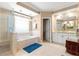 Bathroom with a walk-in shower, soaking tub, and double vanity at 13885 Del Webb Blvd, Summerfield, FL 34491