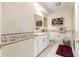 Bathroom with white cabinets and trim, large mirror, shower, and decorative accents at 13885 Del Webb Blvd, Summerfield, FL 34491